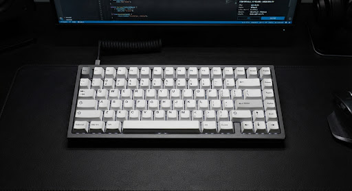 Overhead shot of a minimalist mechanical keyboard with white keycaps on a dark grey aluminum chassis