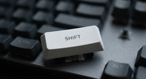 Close-up of a single white keycap with minimal typography